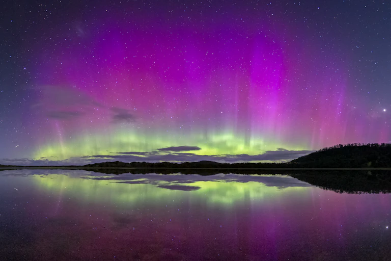 The Aurora Australis, or Southern Lights, reflected in the water.