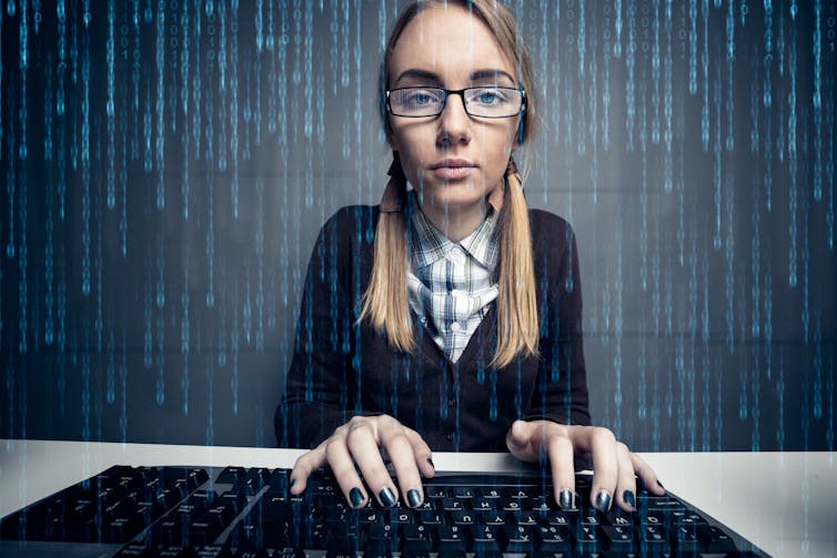 A girl at a computer surrounded by zeros and ones as binary code.