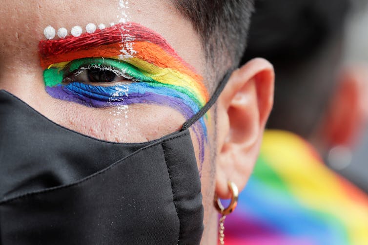person with rainbow eyeshadow and mask