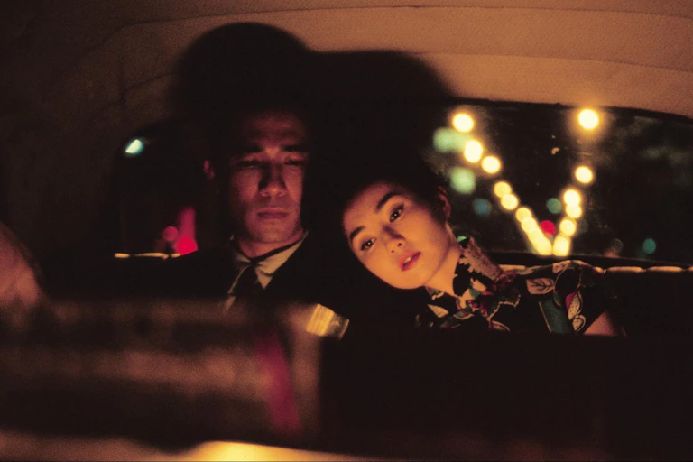 Film still: a man and a woman in the back seat of a car