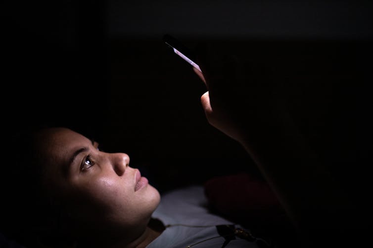 woman with phone in bed