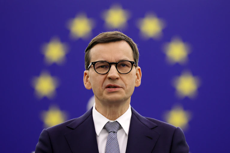 Polish Prime Minister Mateusz Morawiecki with an EU flag background behind him