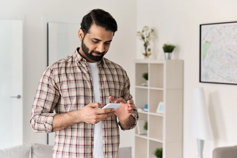A man scrolls on his smartphone.