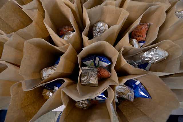 Paper bags filled with sandwiches and snacks