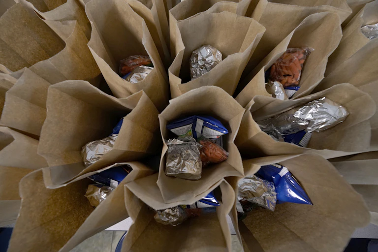 Paper bags filled with sandwiches and snacks