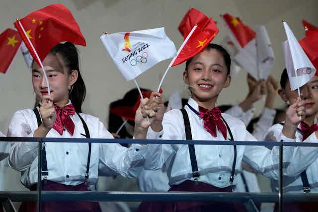 Children wave national flags and Beijing 2022 Winter Olympic Games flags