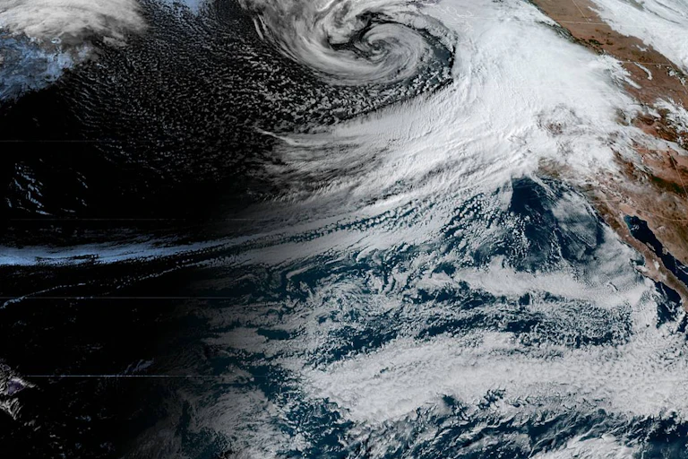 Heavy clouds spiral from the eastern Pacific to California.