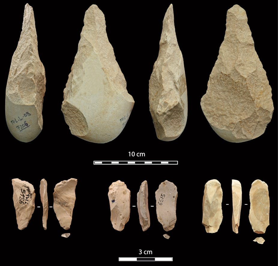 Rocks and pieces of flint shaped into sharp cutting tools are displayed in two rows against a black background.