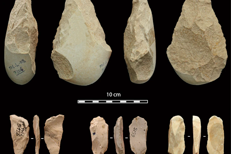 Rocks and pieces of flint shaped into sharp cutting tools are displayed in two rows against a black background.