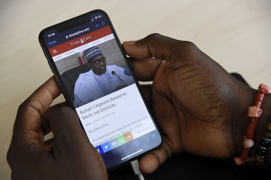 A journalist sources for information with a smartphone on the internet at the Arise News in Ikoyi neighbourhood in Lagos on June 10, 2021. 