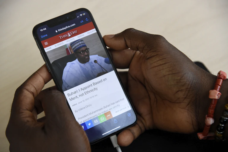 A journalist sources for information with a smartphone on the internet at the Arise News in Ikoyi neighbourhood in Lagos on June 10, 2021.