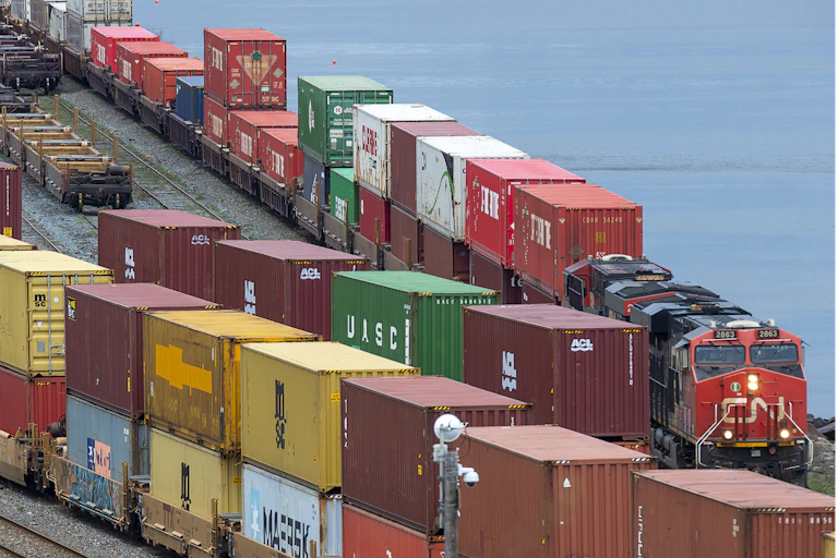 Rows of shipping containers next to a body of water.