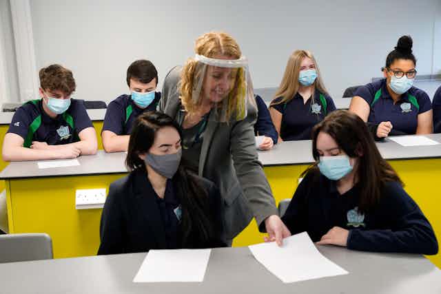 A teacher in a year 11 class wears a face screen