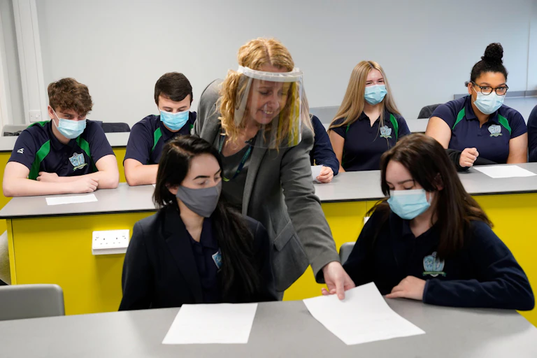 A teacher in a year 11 class wears a face screen