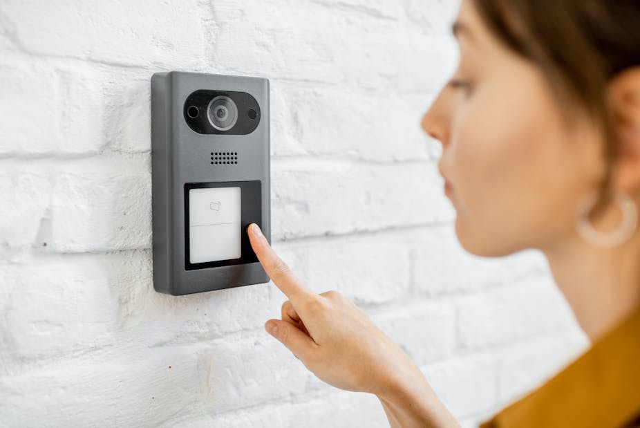 A woman rings a smart doorbell.