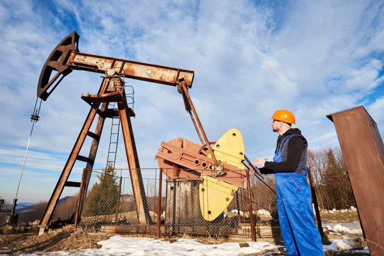An engineer inspects an oil pump.