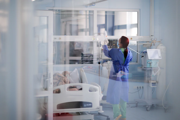 ICU clinician adjust a patient's drip.