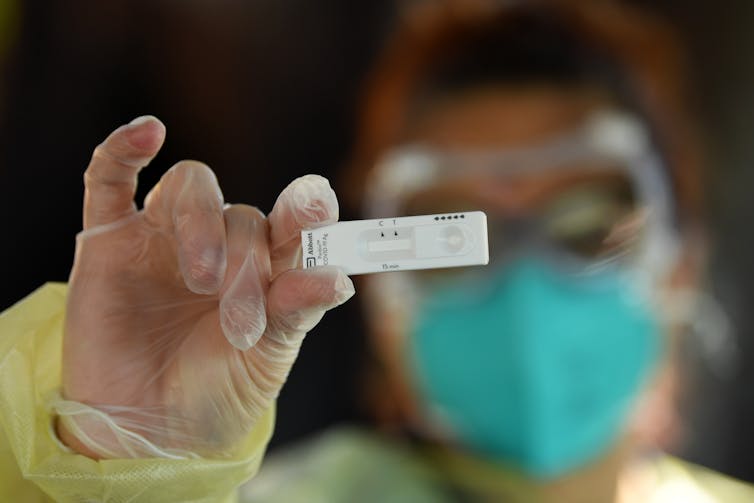 Health worker holding a rapid antigen test