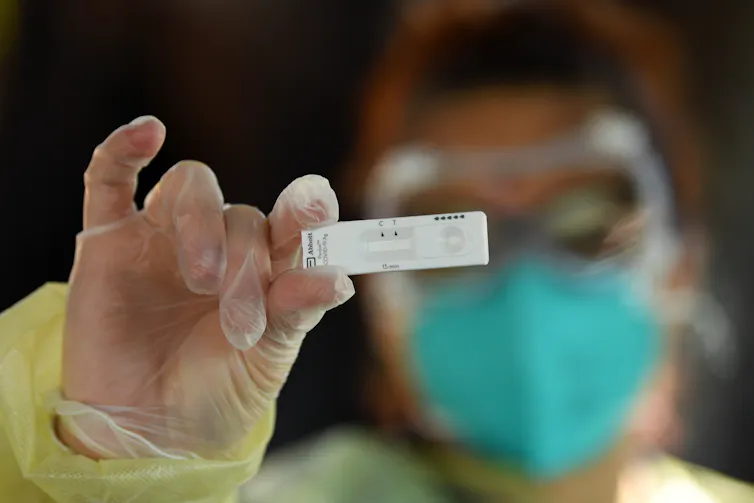 Health worker holding a rapid antigen test