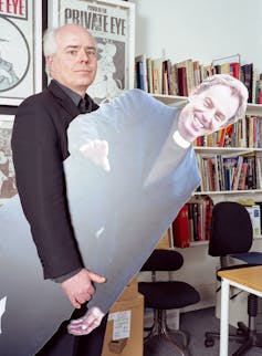 Man holds cutout of prime minister Tony Blair.