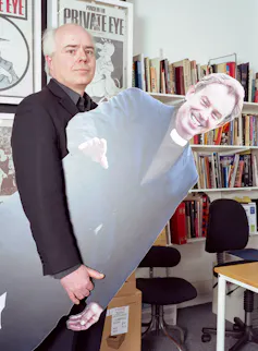 Man holds cutout of prime minister Tony Blair.