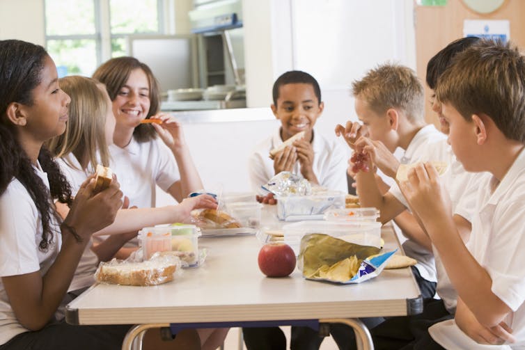 A group of school students eating lunch.