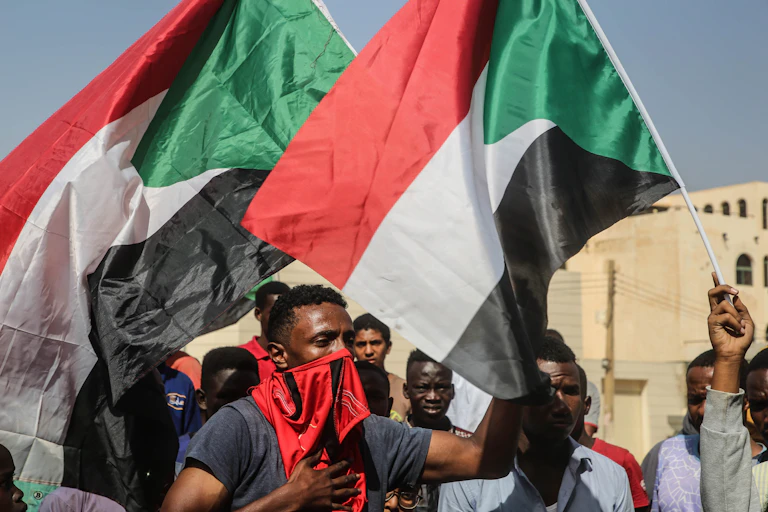 Men hold flags up in an outdoor setting