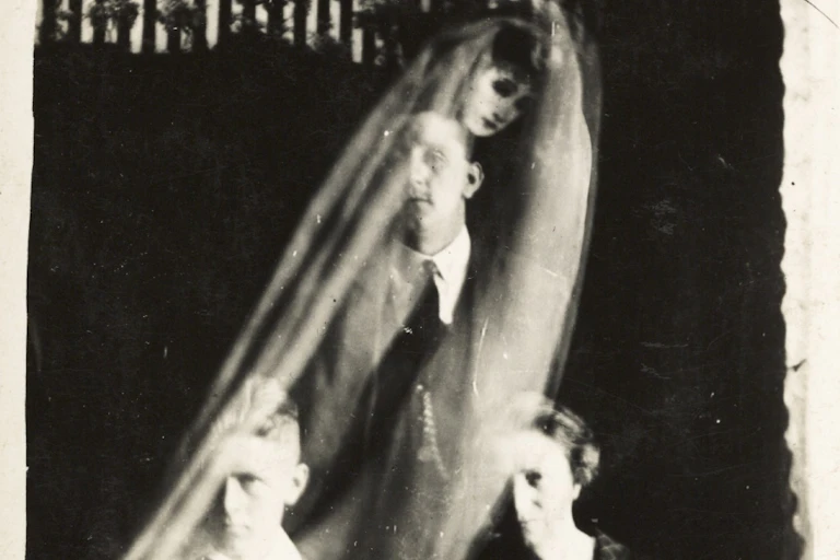A semi-translucent image of a veiled woman seen behind a man.