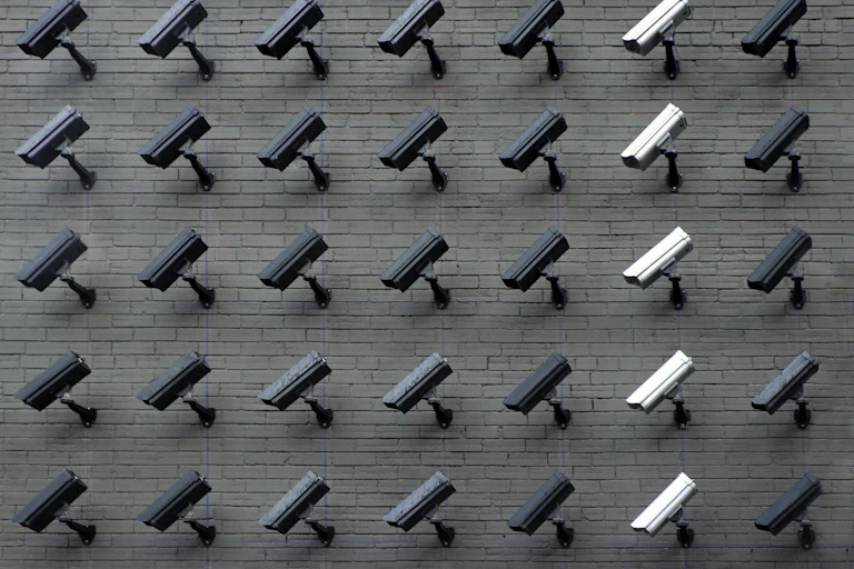 an exterior brick wall of CCTV cameras facing down.