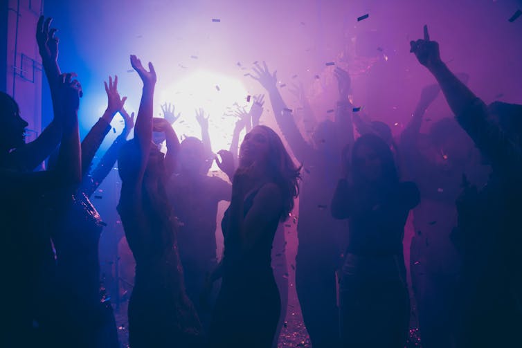 A group of people dancing in a dark nightclub.