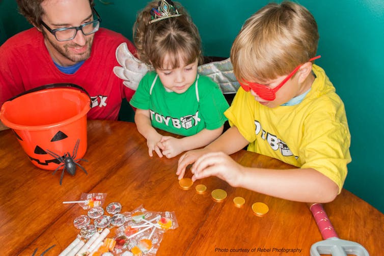 A father and two children sort candy.