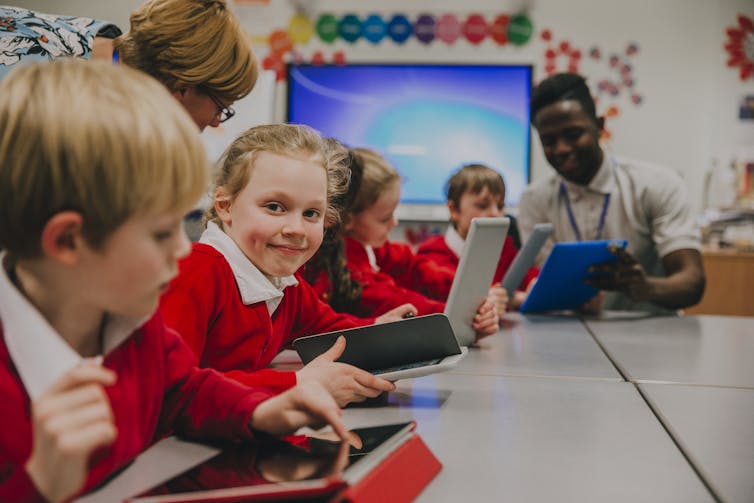 Children using laptops in a classroom.