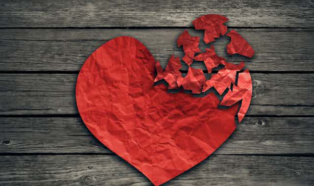 Red paper heart shape torn to pieces