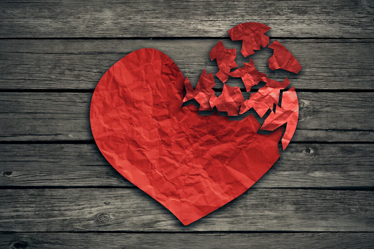 Red paper heart shape torn to pieces