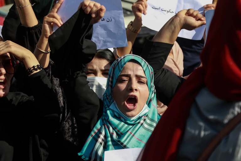 afghan women, some in masks, protest against the closure of girls' schools, October 2021.