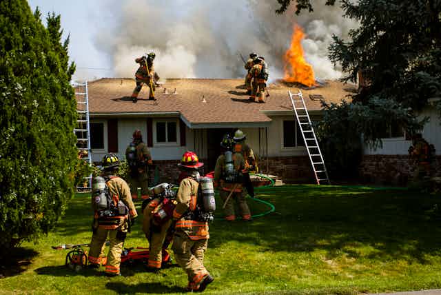 Firefighters rush to put out a burning home.