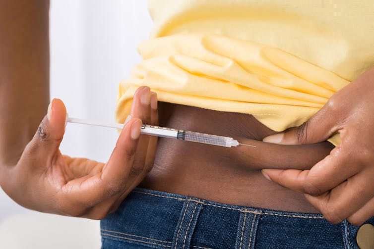 Une jeune femme s’injecte de l’insuline dans le ventre