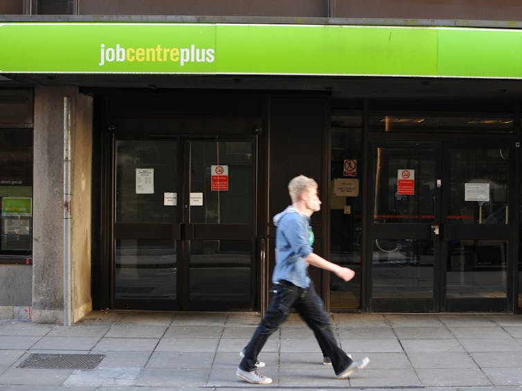 Two people walking past a job centre