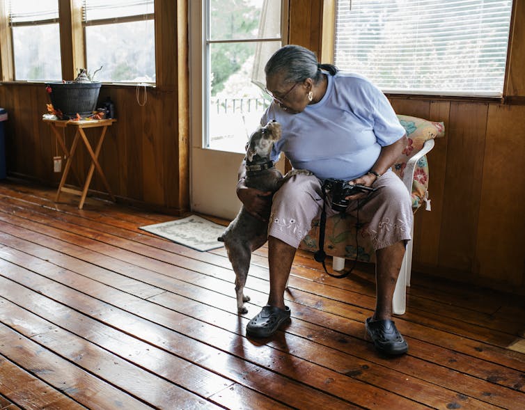 Woman leans down to pet her dog