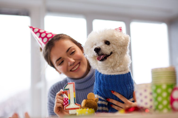 woman with party hat with dog