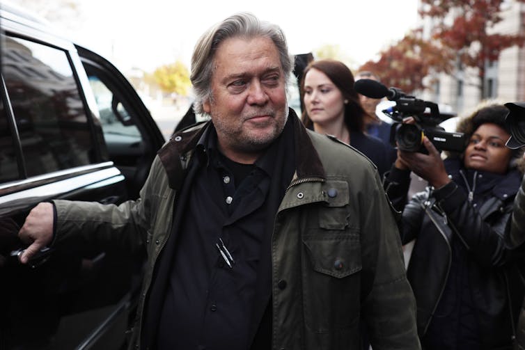 Steve Bannon getting into a limousine amid a crowd.