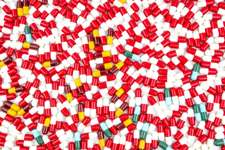 Antibiotic capsules filling white background.