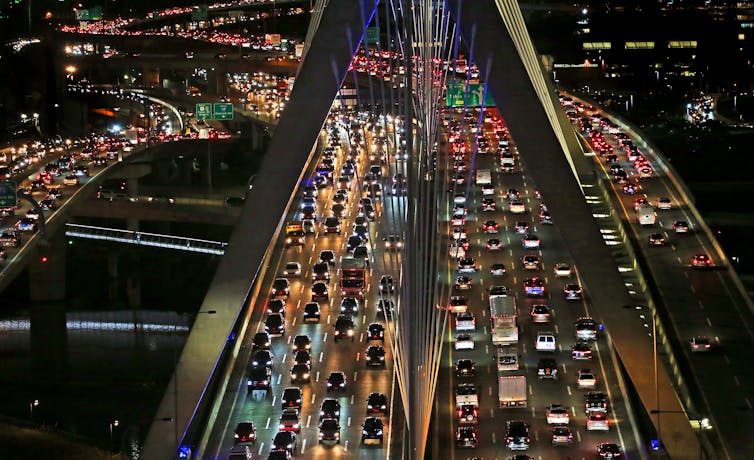 Traffic lights up the evening on a Boston bridge. Transportation is now the leading source of carbon dioxide emissions in the U.S., followed by electricity. David L. Ryan/The Boston Globe via Getty Images.