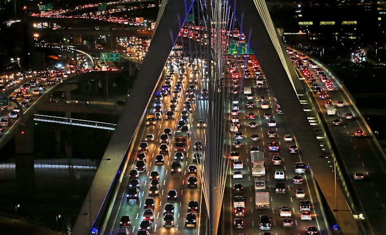 Traffic lights up the evening on a Boston bridge