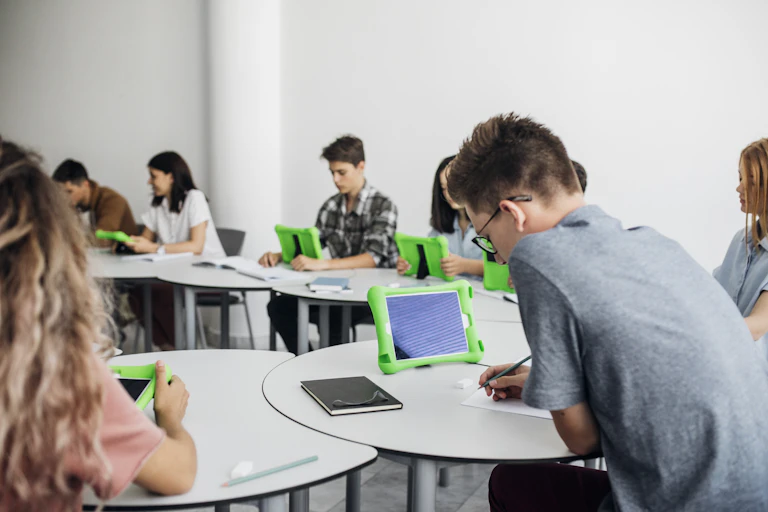 Children on ipads at tables.