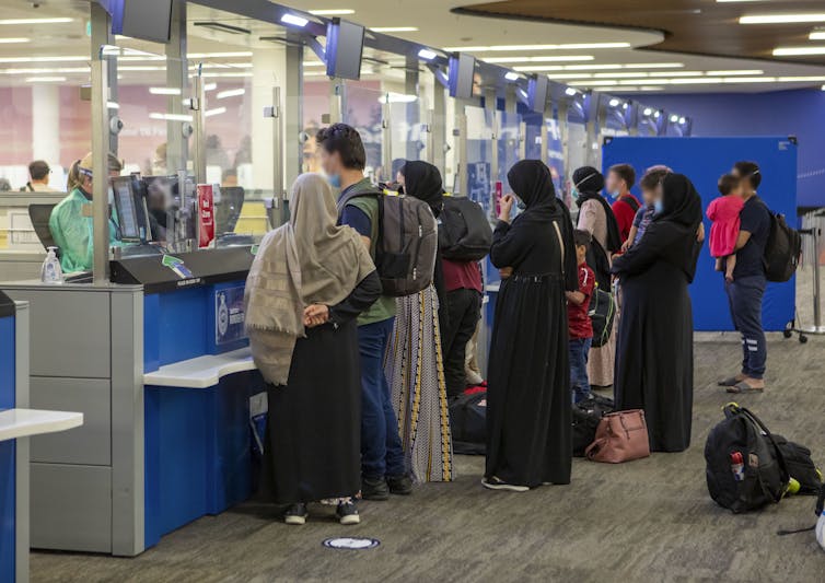 Afghan refugees line up at customs.