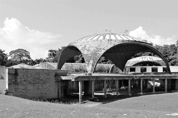 Foto em preto e branco de um edifício arqueado ao ar livre.