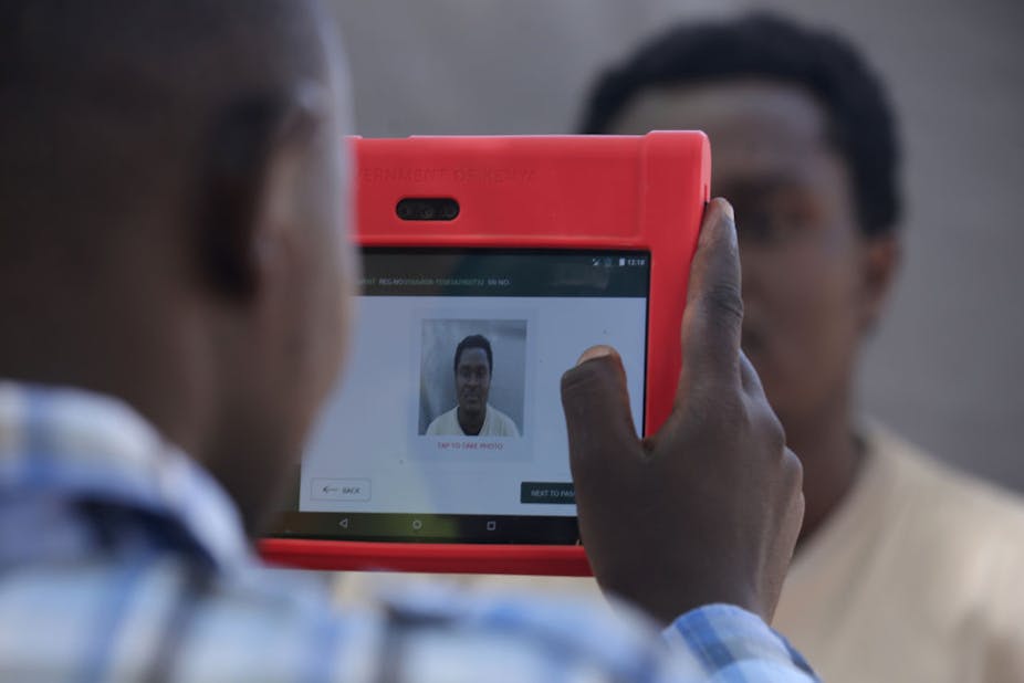 Registration official captures a man's photo for digital ID