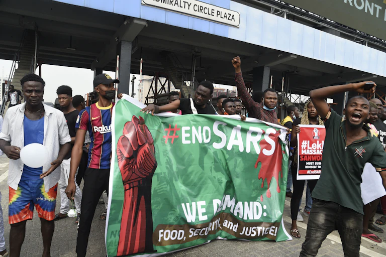 A group of men holding a banner at a toll gate.