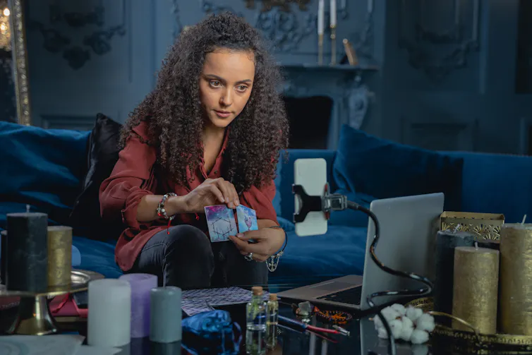 Young woman drawing the tarot on social media.
